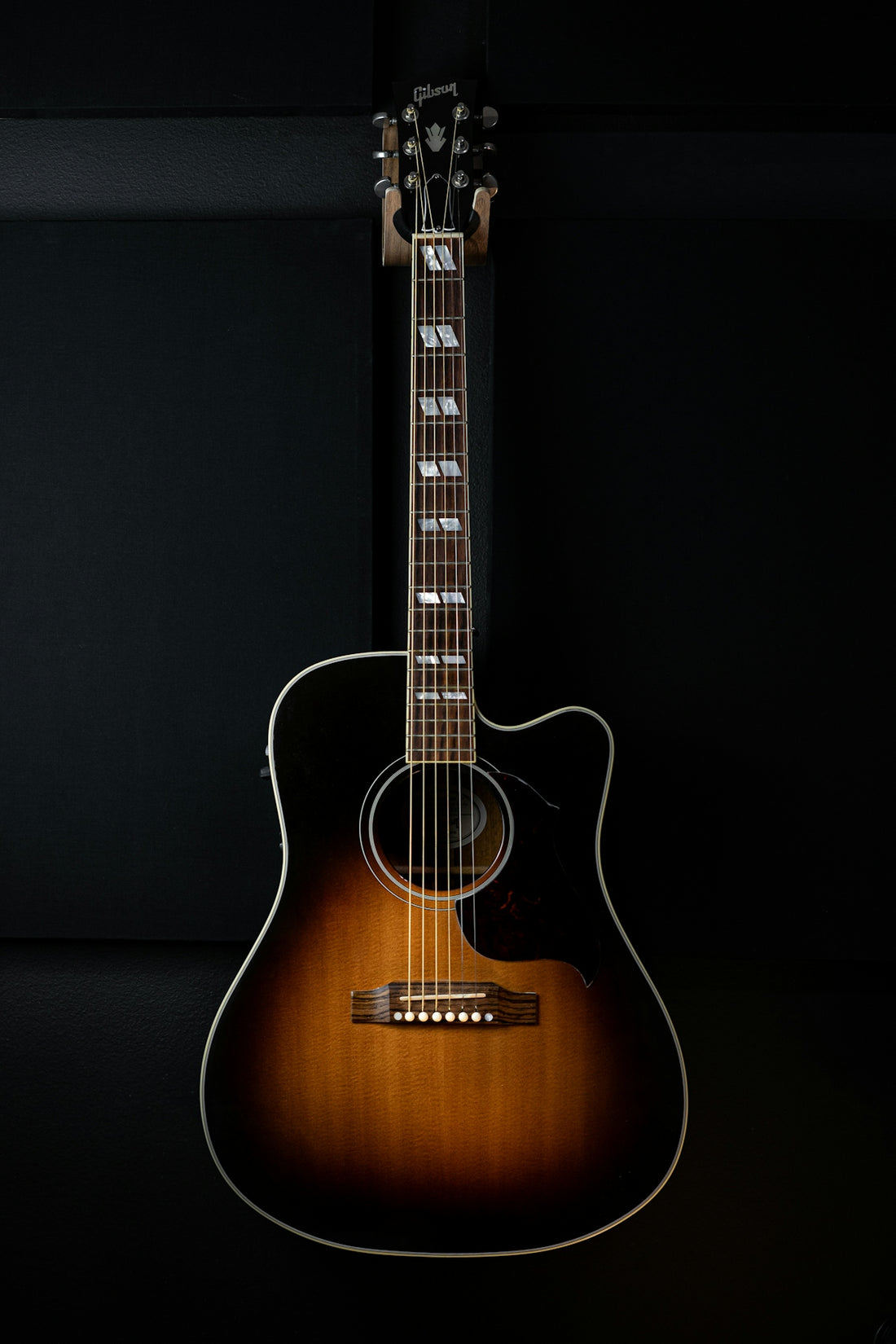 an acoustic guitar sitting on a black background