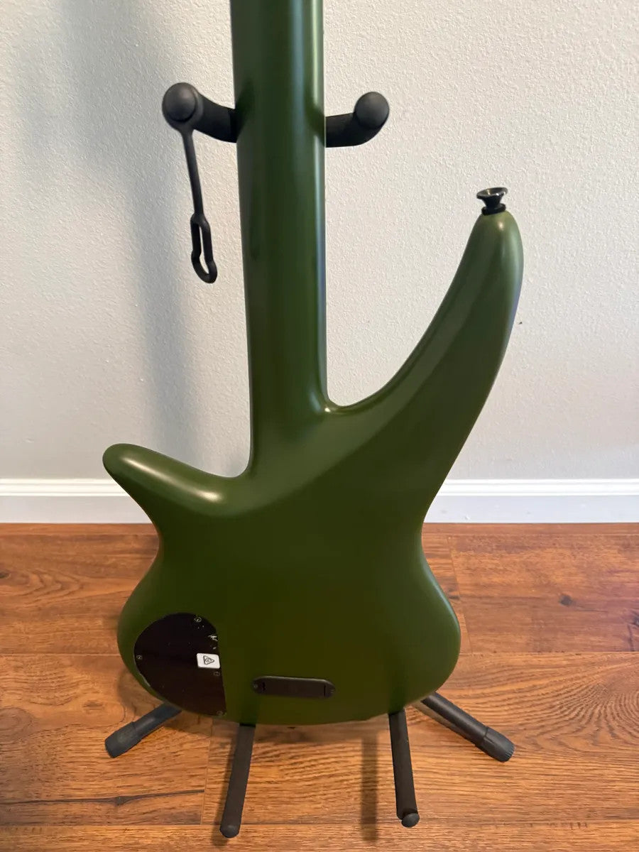 Used Jackson X Series Spectra Bass SBX IV in matte army drab finish, showcasing the body and neck of the electric guitar.