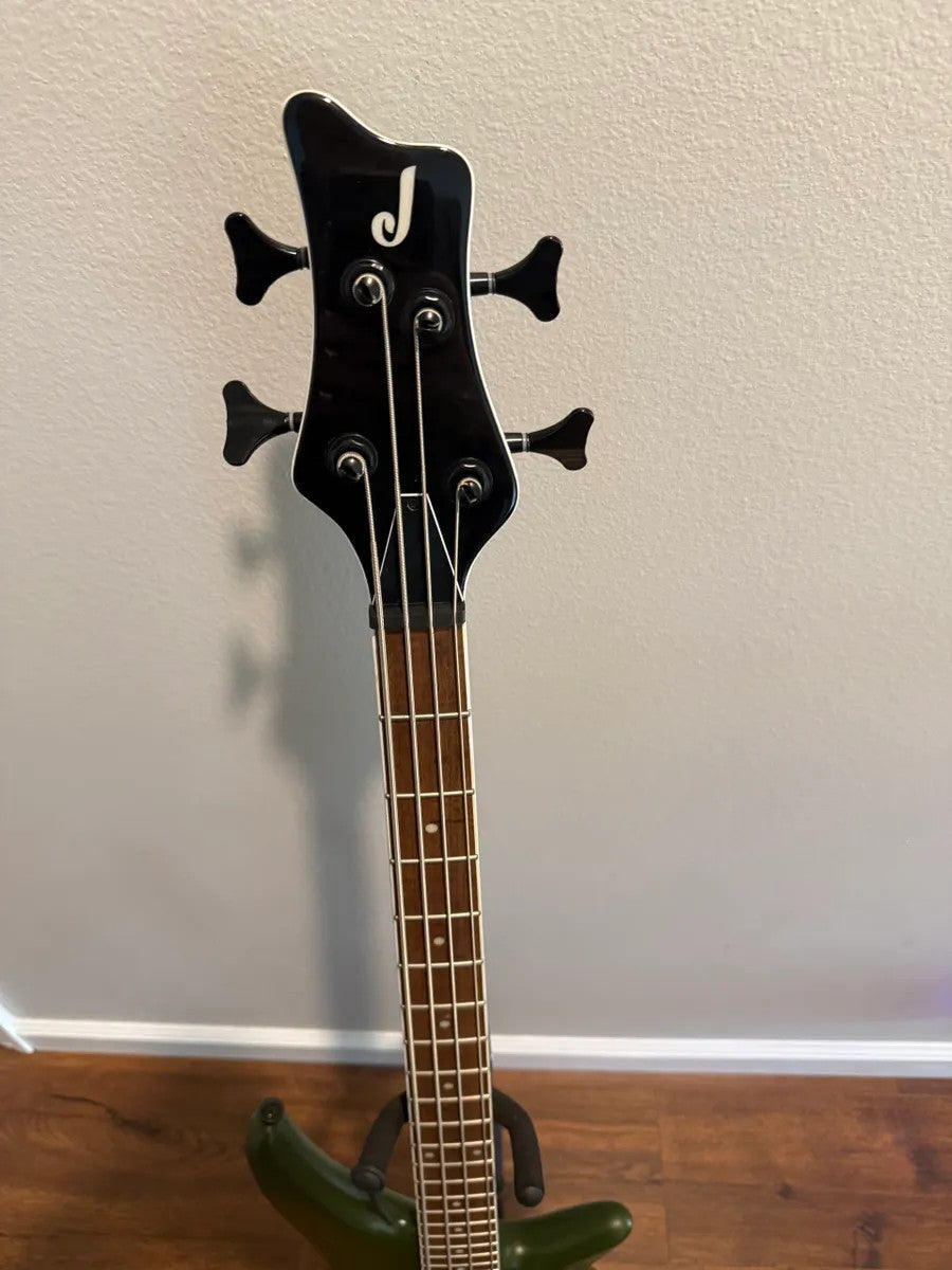 Used Jackson X Series Spectra Bass SBX IV in Matte Army Drab, showcasing its sleek body and electric bass design.