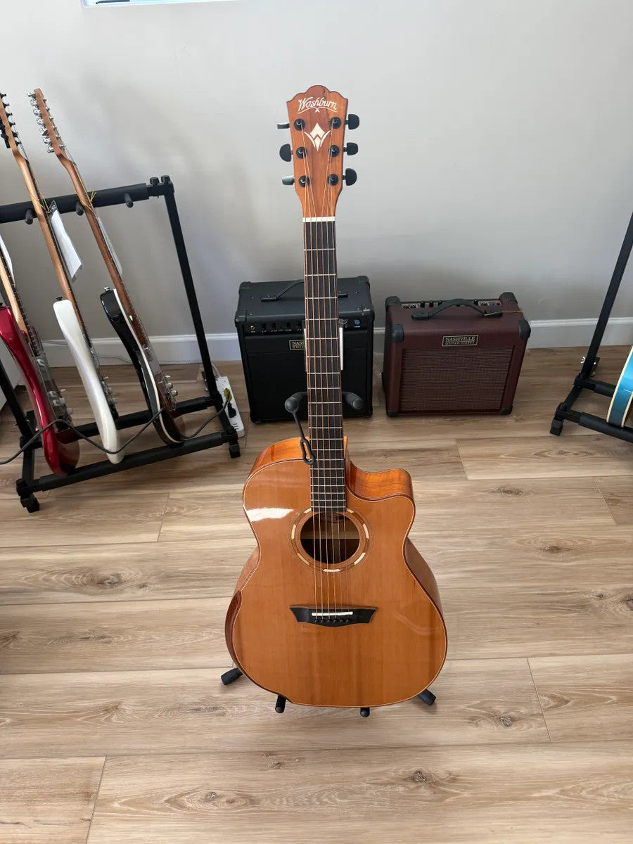Used Washburn Comfort Series WCG66SCE acoustic electric guitar with a sleek design and natural wood finish.